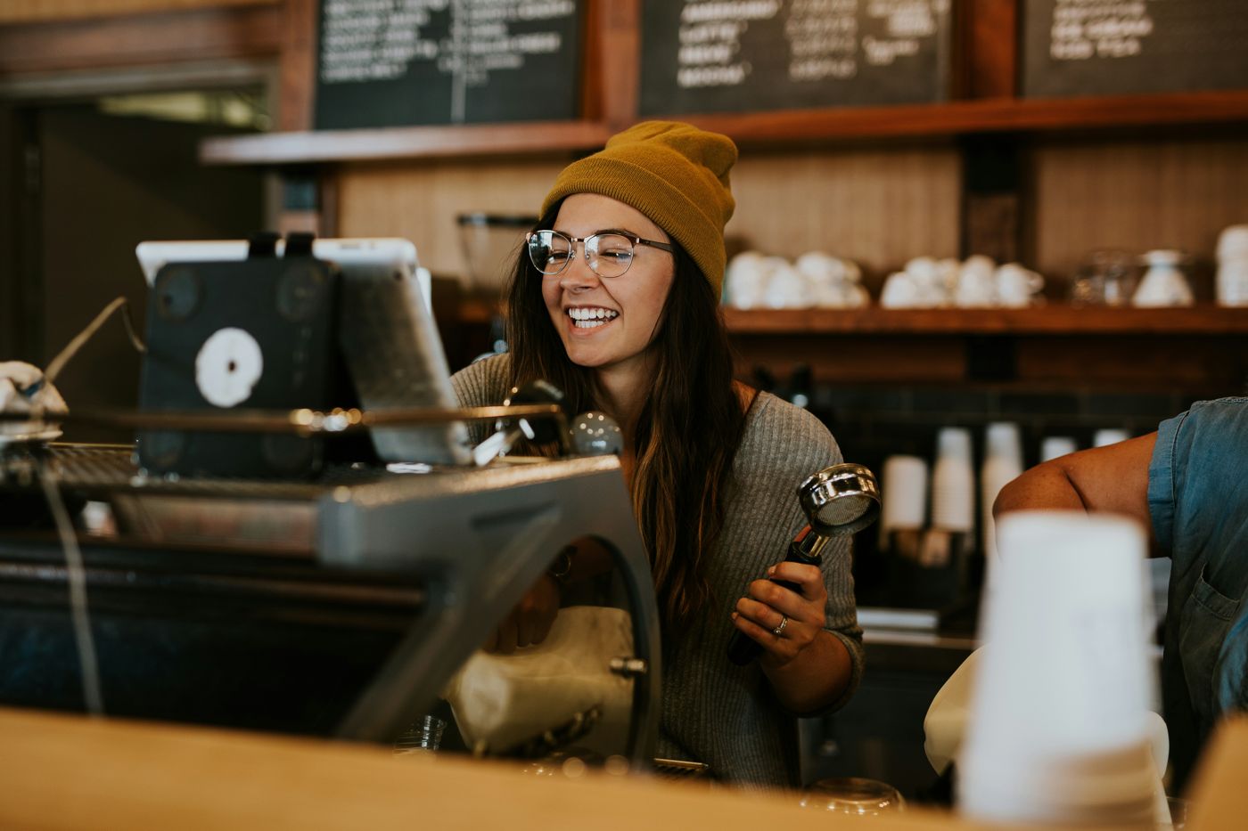 Barista preparing coffee behind a café counter